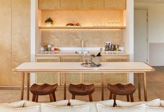 The Standard Hua Hin: Stylish beach hotel interior. Bar area with champagne bucket, glasses, and wooden stools. Gay travel luxury.