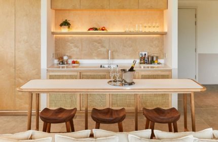 The Standard Hua Hin: Stylish beach hotel interior. Bar area with champagne bucket, glasses, and wooden stools. Gay travel luxury.