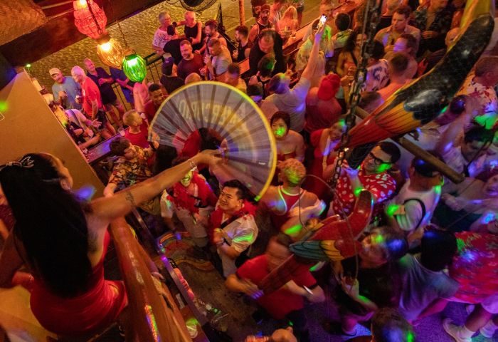 Crowded Mr. Flamingo gay bar in Puerto Vallarta. Drag queen performance, colorful lights, and lively atmosphere. Gay travel destination.