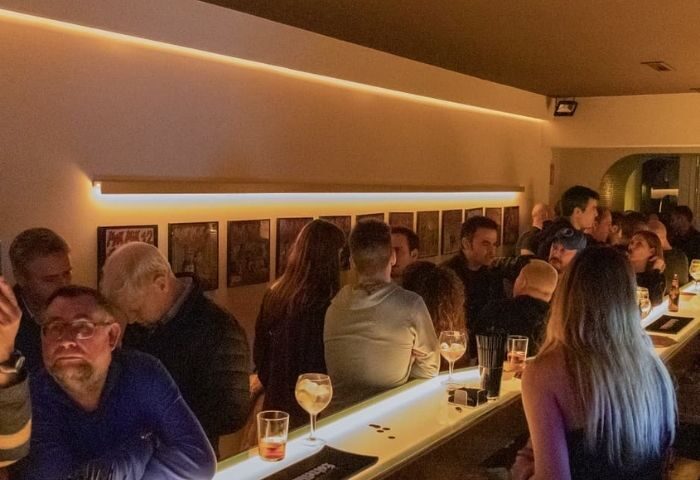 Barcelona gay bar scene: A lively crowd gathers at a museum-themed bar. Patrons enjoy drinks in this popular gay-friendly Barcelona nightlife spot.