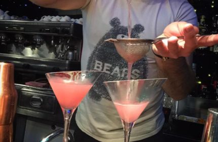 Bartender making pink cocktails at My Bar, Rome. Gay bar with Bears t-shirt. Gay travel advice, nightlife, and Rome's gay scene.