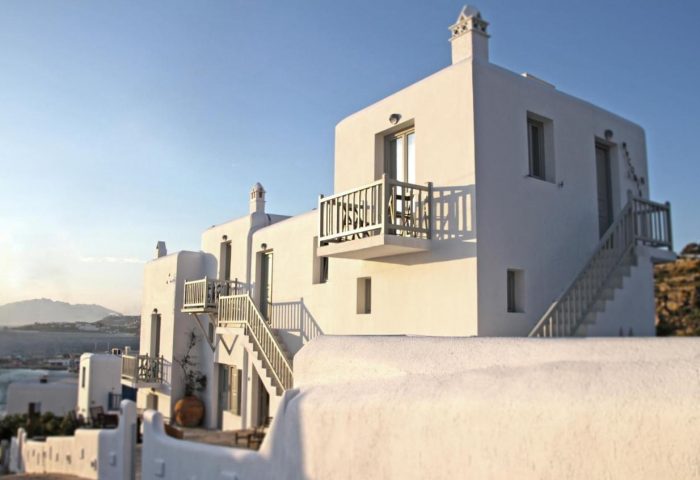 Myconian Inn, a gay budget hotel in Mykonos. Traditional white Cycladic architecture with balconies and stairs. Gay travel advice.