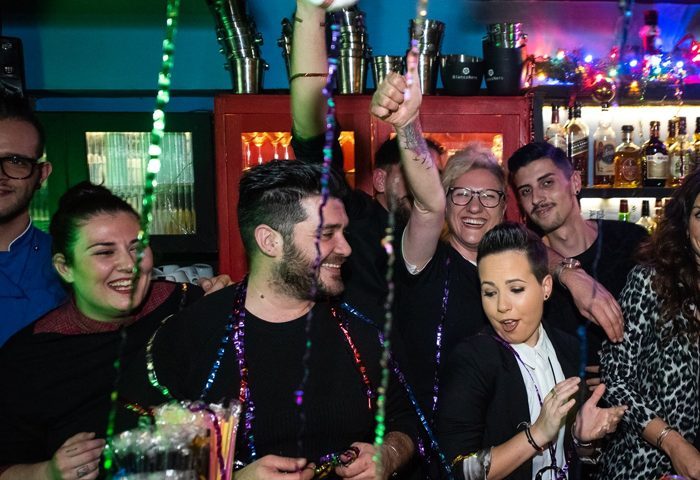 Myrovolos bar staff celebrating, gay travel destination. Group of happy people, bar scene, nightlife. Myravolos party, fun, and camaraderie.