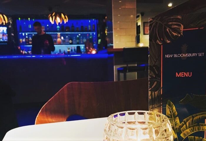 New Bloomsbury Set, a top gay cocktail bar in London. Interior view with the menu on the table and a bartender in the background.