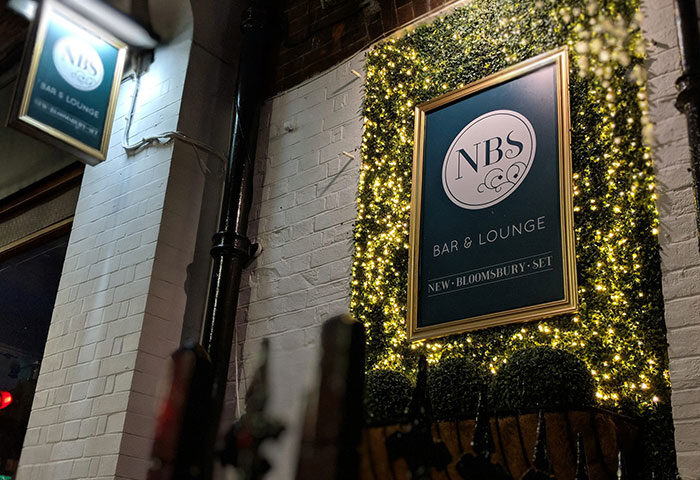 New Bloomsbury Set, London's best gay bar. NBS Bar & Lounge sign, with fairy lights. Cabaret venue in London for gay men travelers.