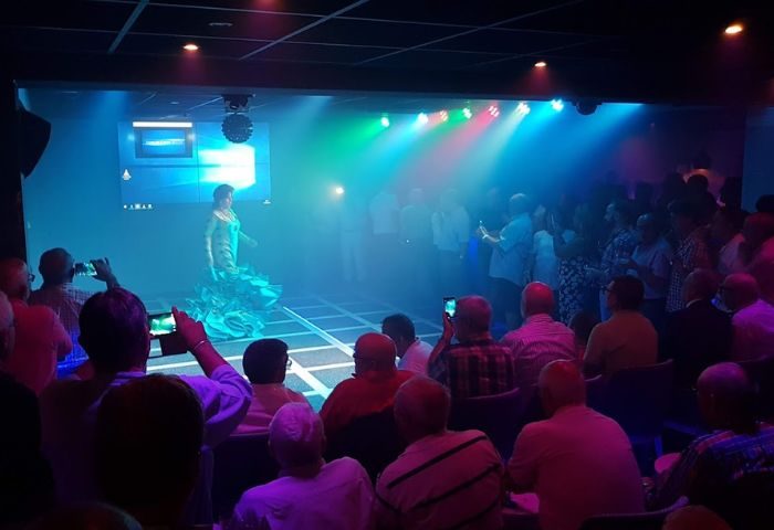 Incognito gay bar in Benidorm, Spain. A performer in a dress is on stage, with an audience of gay men watching and taking photos. Nightlife.