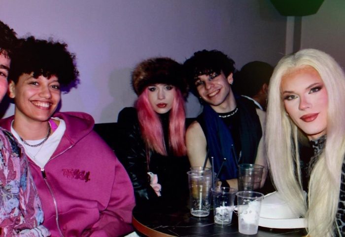 Gay nightlife in Manchester: Friends at New Union bar. Diverse group, including drag queen, enjoying drinks. Gay travel scene.