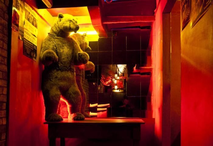 Nicho Bears Bar gay party in Mexico. Bear statue on a table, with mirrors and red lighting. Gay travel advice.