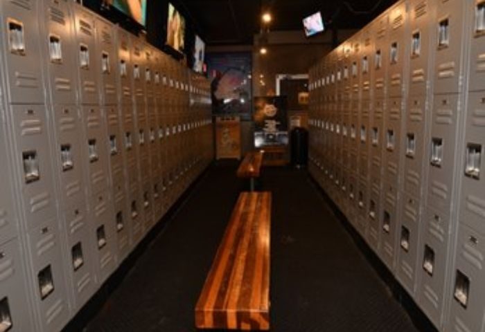Locker room at North Hollywood Spa. Lockers line the walls with wooden benches in the center aisle. A gay spa experience in North Hollywood.