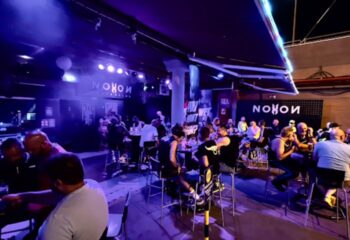 Gran Canaria gay nightlife at Noxon Club. Men gather at tables in the lively gay cruise club in Gran Canaria, enjoying drinks and socializing.