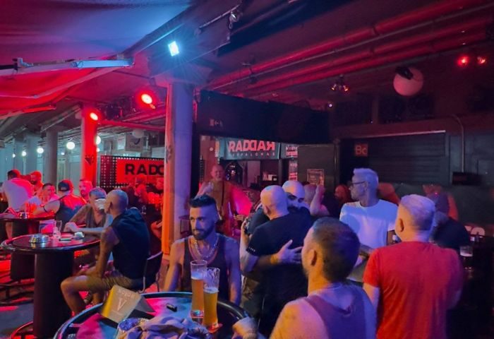 Noxon Terrace Gay Bar in Gran Canaria: Men socializing at a gay bar, enjoying drinks and conversation in a vibrant, welcoming atmosphere.