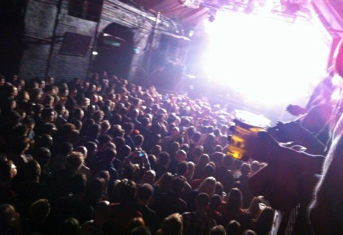 Packed dance floor at G-A-Y Heaven, a popular gay club in Soho, London. Bright stage lights illuminate the crowd. Nightlife scene.