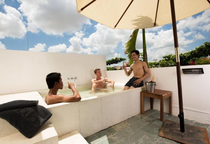Gay men relax in a tub at Rambutan Resort, Phnom Penh. A top gay hangout hotel in Phnom Penh, Cambodia, with champagne and good times.