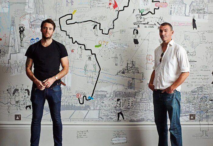 Gay honeymoon hotels Shoreditch: Two men at Andaz London Liverpool Street, a concept by Hyatt. Wall art of London. Gay travel advice.