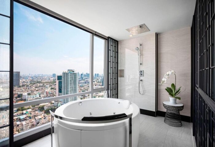 Bangkok Marriott Surawongse Hotel bathroom. Silom City Center gay hotel with tub, shower, and city view. Perfect for hot gay travel.