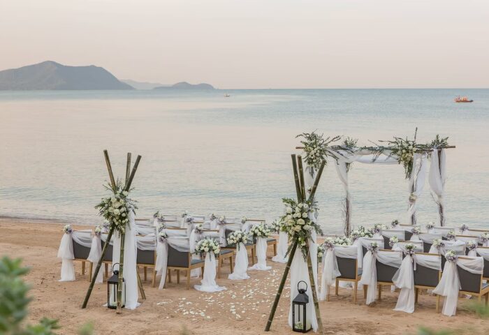 Beachfront gay wedding at Renaissance Pattaya Resort. Chairs and floral arch set up on the sand with ocean view. Number one hotel for gay weddings.