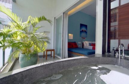 Rambutan Resort Phnom Penh: Cheap gay hotel room view with bathtub, balcony, and bed. A relaxing gay travel destination in Cambodia.