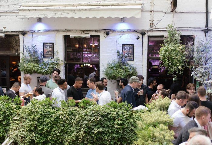 The Yard Bar, Soho, London. Outdoor garden of a gay bar. People socializing in the garden area. Number one gay bar in London.