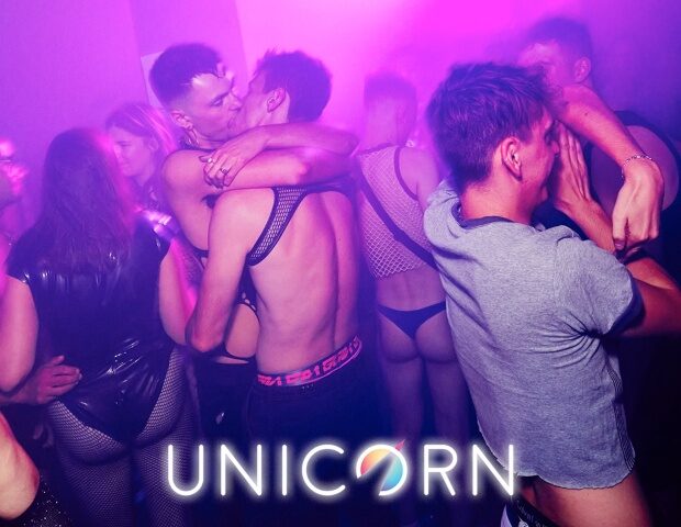Gay club Unicorn London scene. Men dancing, kissing, and wearing underwear. Nightlife at gay bar with live DJ and dark orgy room.