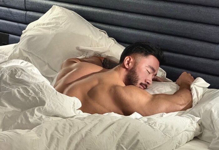 Gay couple hotels Singapore: Man asleep in bed at voco Orchard Singapore, an IHG Hotel. Number one gay hotel for gay travel advice.