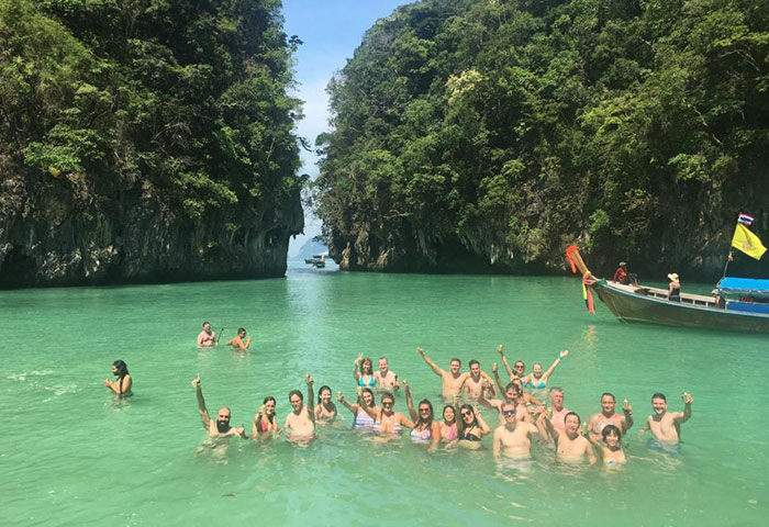Gay travelers at Pak Up Hostel, a gay-friendly hostel. Group of men in Thailand's ocean, enjoying solo gay travel. Number one hostel.