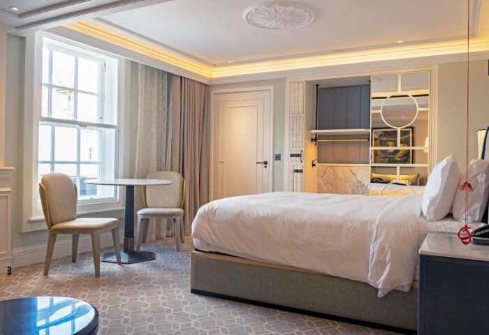 Great Scotland Yard Hotel's honeymoon suite, a top gay hotel in London. Room features a bed, chairs, table, and elegant decor.