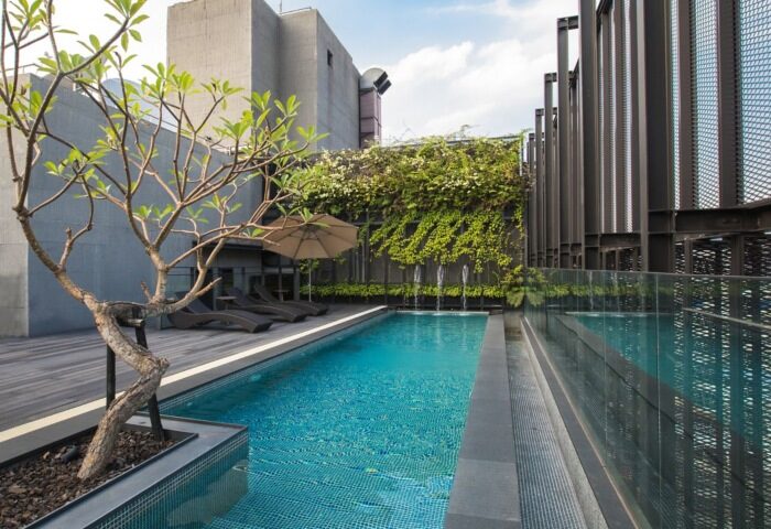 Hotel Proverbs Taipei rooftop pool, near gay bar. Relaxing deck chairs, lush greenery, and modern design. Perfect for gay travelers.