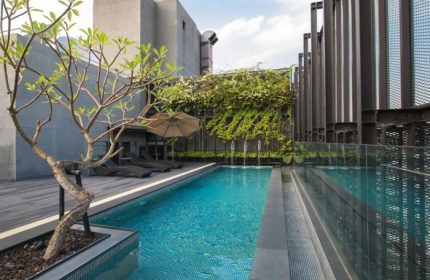 Hotel Proverbs Taipei rooftop pool, near gay bar. Relaxing deck chairs, lush greenery, and modern design. Perfect for gay travelers.