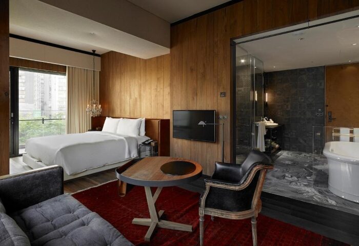 Hotel Proverbs Taipei room. One of Taipei's number one gay hotels for Taipei PRIDE. Bed, bath, chair, and table in a modern, stylish room.