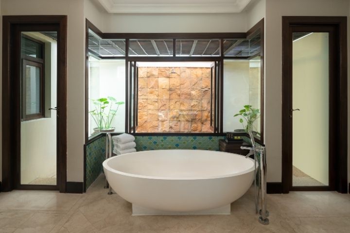 InterContinental Pattaya Resort bathroom with stone shower, round tub, plants. Gay couples honeymoon beach resort in Thailand. IHG Hotel.