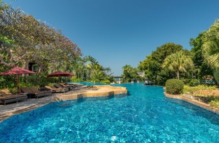 InterContinental Pattaya Resort pool view. Luxury beachfront hotels for gay men. Tropical landscape, blue water, and lounge chairs.