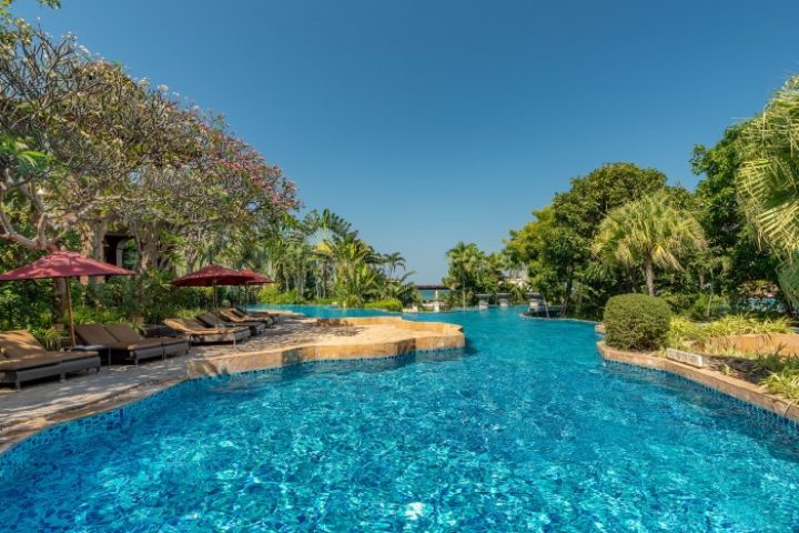 InterContinental Pattaya Resort pool view. Luxury beachfront hotels for gay men. Tropical landscape, blue water, and lounge chairs.