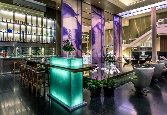 Pullman Bangkok King Power lobby. Luxury gay hotel near Weekend Market. Features a bar, lounge area, and modern design.
