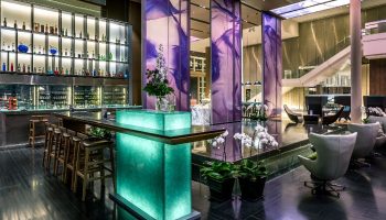 Pullman Bangkok King Power lobby. Luxury gay hotel near Weekend Market. Features a bar, lounge area, and modern design.