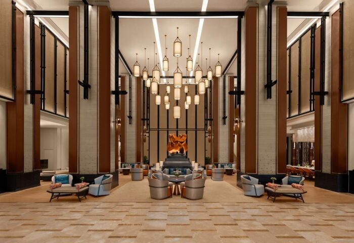 Chiang Mai Marriott Hotel's lobby. Luxury gay hotel near gay saunas. Grand hall with seating areas, chandeliers, and modern design. Upscale travel.