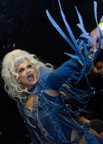 Drag queen performing at a gay bar in Vancouver. Best nightlife in gay Vancouver. Travel guide. Denim dress with blue laces. Blonde wig.