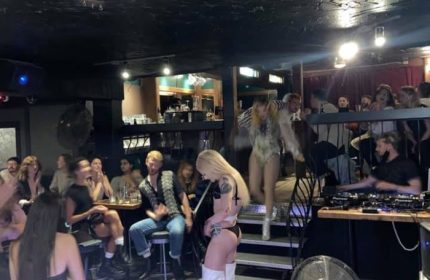 Nightlife at Numbers Cabaret in Vancouver. Drag queens perform on stage. DJ plays music for the audience. Gay travel advice.