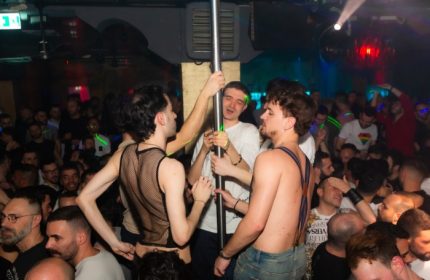 ONEWAY Discoclub Milan: Gay men dancing at a crowded party. Some are shirtless, others wear mesh. A pole is the focus of attention.