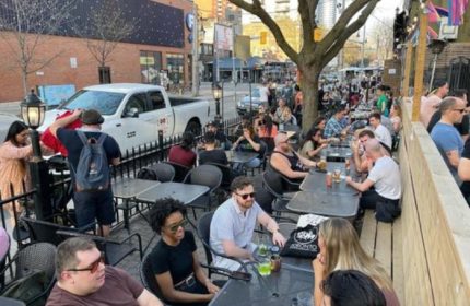 O'Grady's on Church bar in Toronto: Outdoor patio scene with diverse crowd enjoying drinks. Gay-friendly travel destination in Canada.