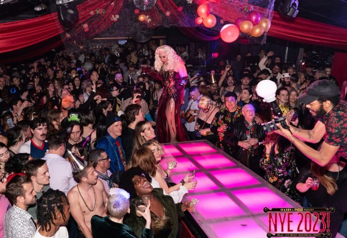 Oasis drag cabaret in San Francisco. Drag queen on stage, surrounded by a crowd of people at a New Year's Eve party. Gay nightlife.