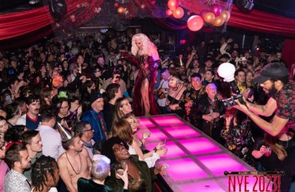 Oasis drag cabaret in San Francisco. Drag queen on stage, surrounded by a crowd of people at a New Year's Eve party. Gay nightlife.