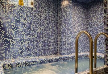 Olissipo gay bathhouse in Lisbon. Mosaic tiled bath with metal ladder. Gay travel advice for men in Portugal.