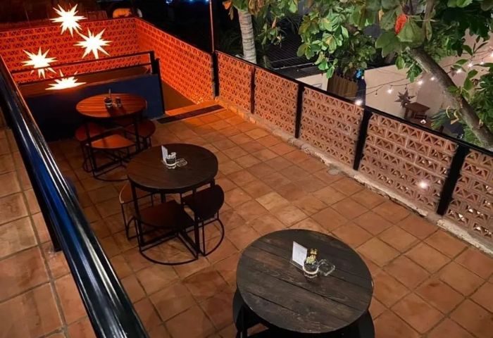 Rooftop patio at One Six One PV gay bar in Puerto Vallarta. Tables, chairs, and decorative lighting create an inviting atmosphere.
