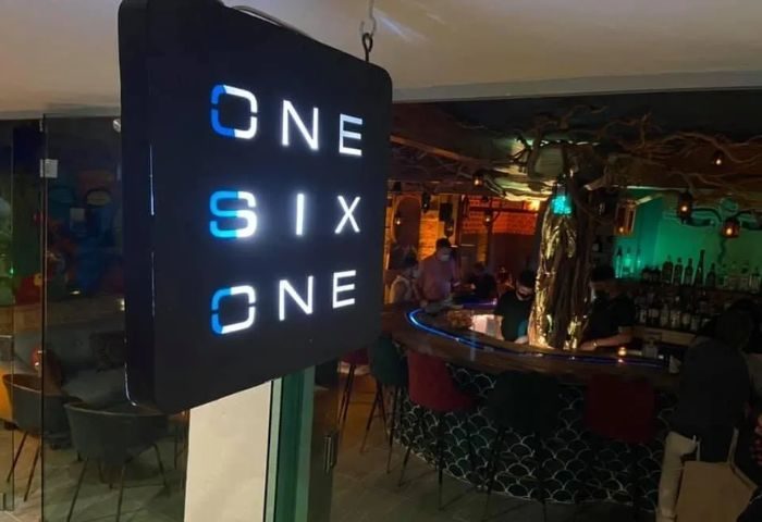 One Six One gay bar in Puerto Vallarta. Interior view of the bar with the sign One Six One and people at the bar.