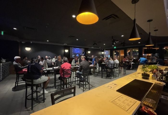 OneEleven Bar lounge. Interior view of the bar, patrons at tables, bar counter in foreground. Gay travel advice.