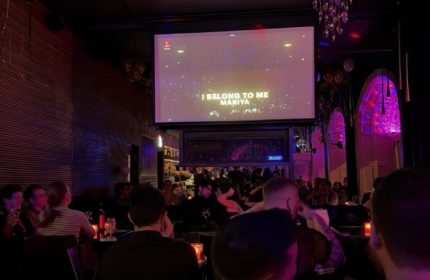 Oscar Bar Cafe Copenhagen: Gay bar patrons enjoy karaoke night. A fun gay nightlife spot for travel advice in Copenhagen.