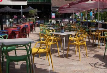 Oscar's Cafe Bar Dublin outdoor seating area. Tables and colorful chairs under umbrellas. Gay travel advice for Dublin, Ireland.