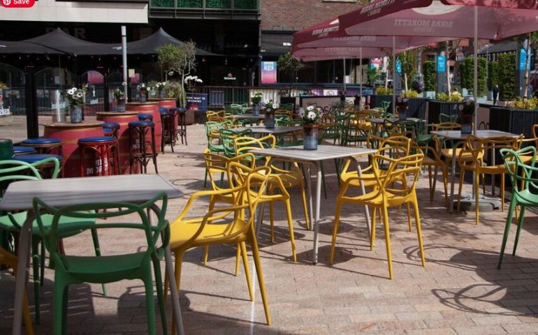 Oscar's Cafe Bar Dublin outdoor seating area. Tables and colorful chairs under umbrellas. Gay travel advice for Dublin, Ireland.