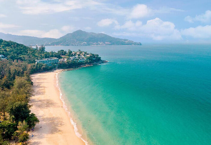 Outrigger Surin Beach Resort, Phuket, Thailand. Aerial view of gay-friendly beachfront hotel, turquoise sea, and sandy beach. Tropical paradise.