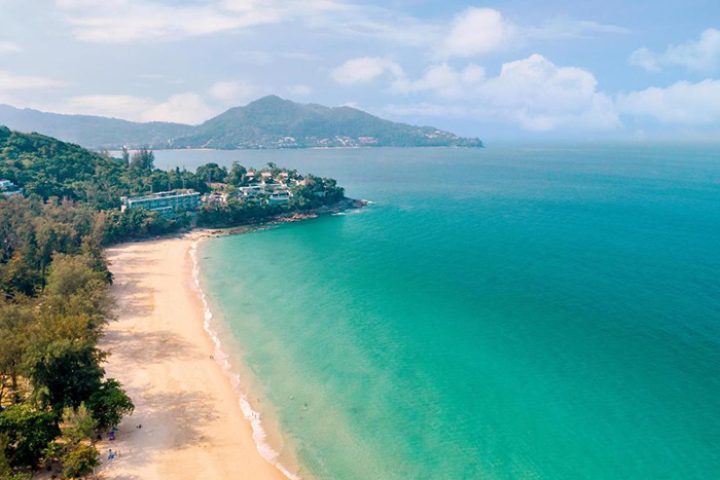 Outrigger Surin Beach Resort, Phuket, Thailand. Aerial view of gay-friendly beachfront hotel, turquoise sea, and sandy beach. Tropical paradise.